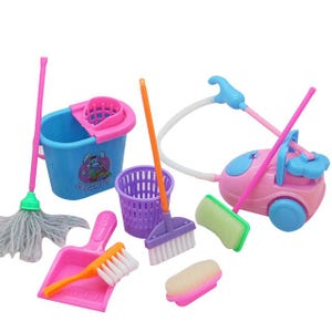 May include: A toy cleaning set featuring a blue bucket with a pink rim and a cartoon graphic, a pink vacuum cleaner with a white hose, a mop with a pink handle, a purple wastebasket, a pink dustpan, a brush, and a sponge.
