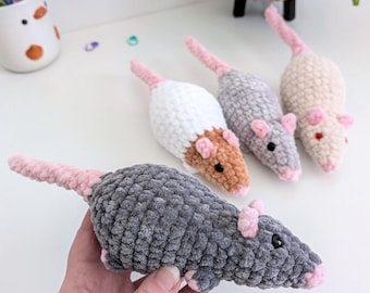 May include: Four handmade crochet plush rats made from soft, textured yarn. One is dark gray, one is white with brown, one is light gray, and one is beige. Each rat features small pink ears, a pink nose, a long pink tail, and black plastic eyes.