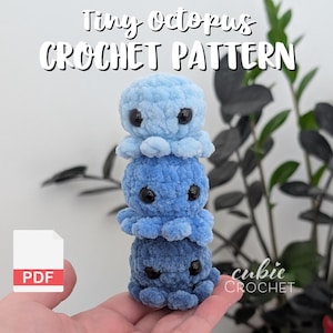 Könnte beinhalten: Ein Stapel von drei gehäkelten Oktopussen in Blautönen. Der obere Oktopus ist hellblau, der mittlere mittelblau und der untere dunkelblau. Der Text "Tiny Octopus CROCHET PATTERN" steht oben.