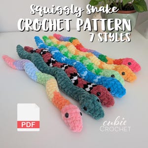 May include: A collection of seven colorful, crocheted snake toys. Each snake features a unique color scheme, including rainbow, teal, red, and blue. The image includes the text "squiggly snake CROCHET PATTERN 7 STYLES" and a PDF icon.