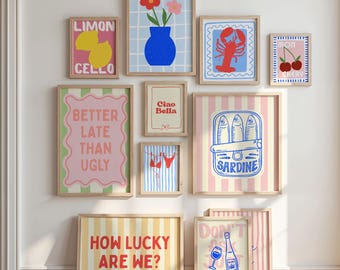 May include: A collection of framed art prints with various designs. Prints include a lemon with "LIMON CELLO", a blue vase with flowers, a red lobster, cherries, "BETTER LATE THAN UGLY", "Ciao Bella", a bikini, sardines, "HOW LUCKY ARE WE?", and "DON'T ASK JUST POUR".
