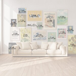 May include: A living room interior with a white couch and a gallery wall of framed art prints. The prints feature various subjects, including a carousel, sunflowers, a wave, and a woman in a hat. The prints are in different sizes and ratios, including 5:7, 7:5, and 14 x 19.8 inches.
