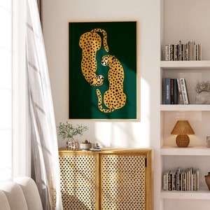 May include: A framed print of two stylized cheetahs in gold and black against a dark green background. The cheetahs are facing each other and appear to be in a playful pose.