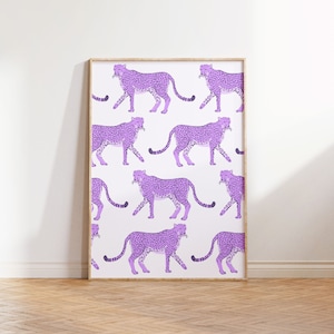 May include: A framed print featuring a repeating pattern of purple cheetahs on a white background.