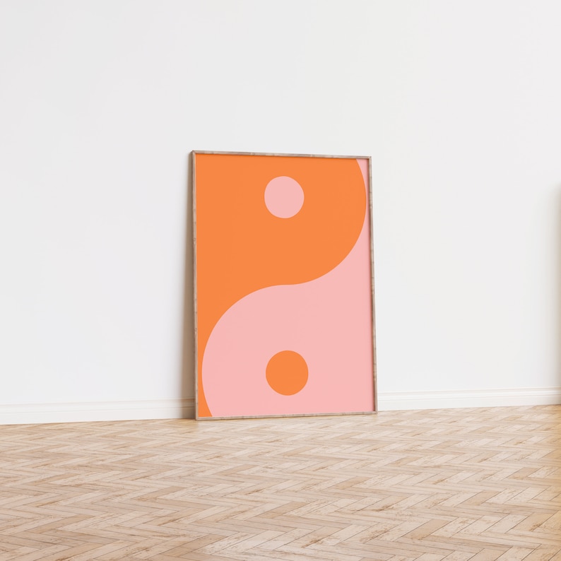 May include: A framed print of a yin yang symbol in orange and pink colours.