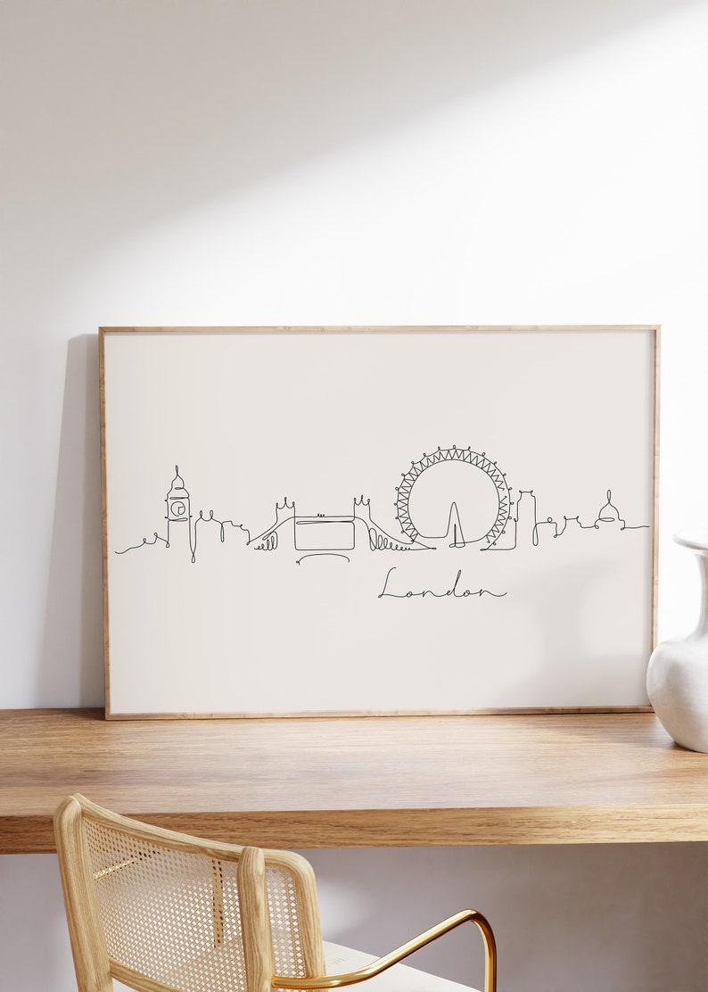 May include: A black and white line drawing of the London skyline, including Big Ben, the London Eye, and Tower Bridge. The drawing is framed and hanging on a wall.