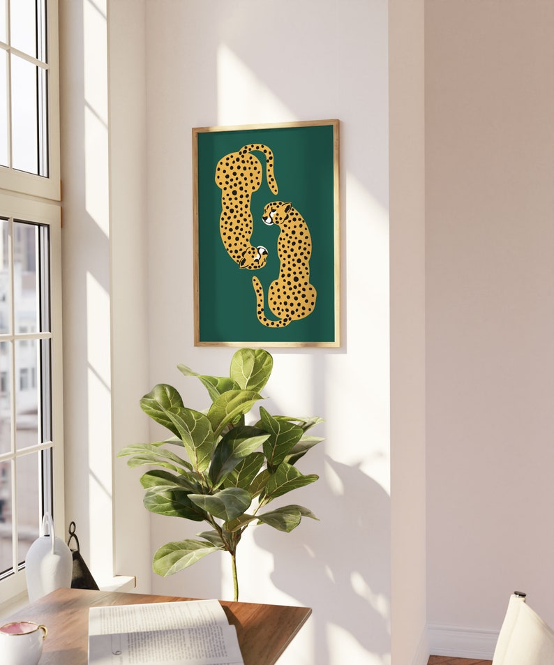 May include: A framed print of two cheetahs in a curled position on a teal green background. The cheetahs are yellow with black spots.