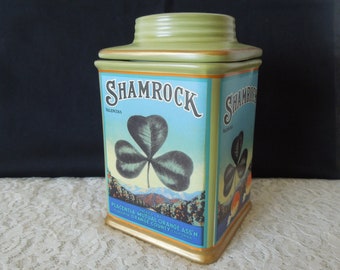 May include: A green ceramic cookie jar with a gold lid and a vintage-style label that reads "Shamrock Valencias" and "Placentia Mutual Orange Ass'n. Placentia Orange County California". The label features a green shamrock.