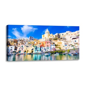 Op de afbeelding: Een kleurrijk Italiaans dorp met een witte koepelkerk op een heuvel met uitzicht op een kalme blauwe haven met boten. De gebouwen zijn geschilderd in tinten geel, oranje, roze en blauw.