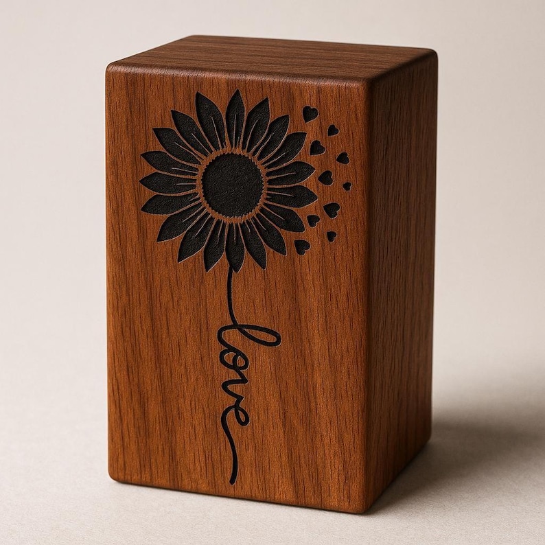 Wooden cremation urn box with engraved sunflower and love text on stone outdoors