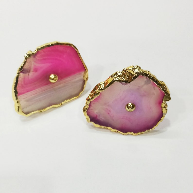 Op de afbeelding: Twee roze en witte agaat ladegrepen met gouden rand. Elke greep heeft een kleine gouden knop in het midden.