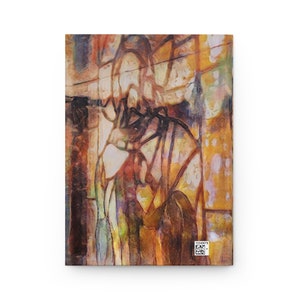 May include: A hardcover journal with an abstract art design. The cover features a blend of warm colors, including yellows, oranges, and browns, with darker lines and shapes. A small barcode is visible on the bottom right corner.