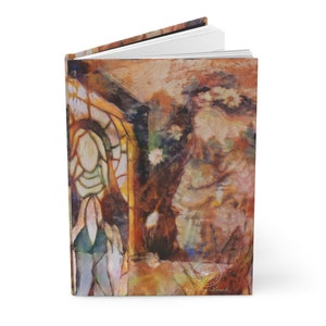 May include: Hardcover journal with an artistic, abstract painting on the cover. The artwork features warm tones of brown, orange, and yellow, with hints of green and white. The design includes a stained-glass window and floral elements.