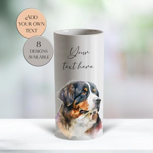 May include: A white cylindrical vase with a watercolour painting of a Bernese Mountain Dog. The vase has the text "Your text here" and two circular stickers that say "Add your own text" and "8 designs available".
