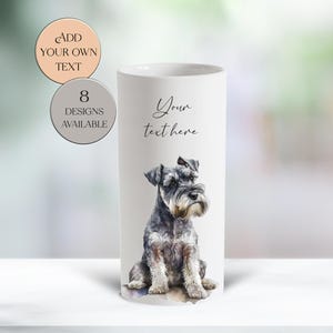 May include: A white cylindrical vase featuring a watercolor illustration of a Schnauzer dog. The vase has the text "Your text here" and two circular graphics that say "Add your own text" and "8 designs available".