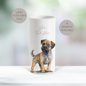 May include: A white ceramic vase featuring a watercolor illustration of a Border Terrier dog. The vase has the text "Your Text Here" and two circular graphics that read "Add Your Own Text" and "8 Designs Available".