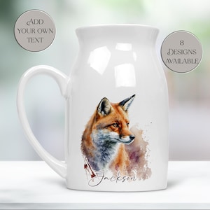 May include: White ceramic jug featuring a watercolour illustration of a fox. The fox is rendered in orange, brown, and white, with the name "Jackson" below. The jug has a large handle and the text "Add Your Own Text" and "8 Designs Available".
