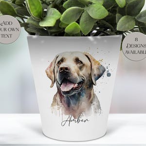 May include: White ceramic plant pot with a watercolour illustration of a Labrador Retriever, named "Amber". The pot contains a green plant and has the text "Add Your Own Text" and "8 Designs Available".