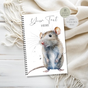 May include: A spiral-bound notebook with a watercolor illustration of a rat. The cover features the text "Your Text HERE" in elegant script. Additional text on the cover indicates "8 Designs Available" and "Add Your Own Text".