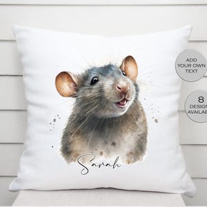 May include: White square throw pillow featuring a watercolor illustration of a rat with gray and brown fur. The rat's name, "Sarah", is written in cursive below the image. Two circular text labels read "Add Your Own Text" and "8 Designs Available."