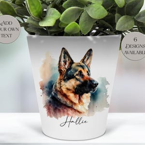 May include: White ceramic plant pot with a watercolour portrait of a German Shepherd dog. The dog has brown, black, and tan fur. The pot is inscribed with the name "Hallie" in cursive and text that says "Add Your Own Text" and "6 Designs Available".