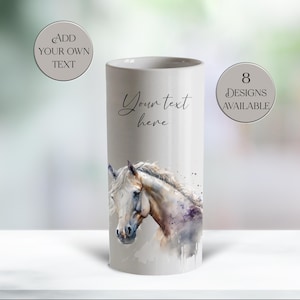 May include: A cylindrical, off-white ceramic mug featuring a watercolor painting of a horse's head. The mug has the text "Your text here" in cursive and the text "8 designs available" in a circle.
