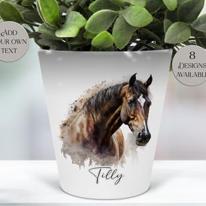 May include: White ceramic plant pot with a watercolour-style portrait of a brown horse with a white blaze. The pot has the name "Tilly" written on it. The pot also has the text "Add Your Own Text" and "8 Designs Available".