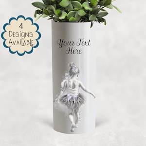 May include: White cylindrical vase with a ballerina illustration. The vase has a drawing of a young girl in a tutu, with the text "Your Text Here" and "4 Designs Available". The vase is topped with green foliage.
