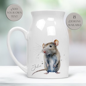 May include: White ceramic jug with a large handle, decorated with a watercolour illustration of a rat. The rat is in shades of brown, grey, and white. The name "Julie" is written in cursive. Text on the jug says "Add your own text" and "8 designs available."