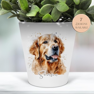 May include: White ceramic planter featuring a watercolor portrait of a Golden Retriever dog. The dog's name, "Samson," is written in cursive below the image. A circular label indicates "7 Designs Available."