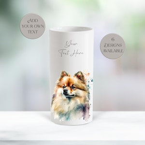 May include: A white ceramic mug with a watercolour illustration of a Pomeranian dog. The mug has the text "Your Text Here" and the option to "Add Your Own Text". The mug also states "6 Designs Available".