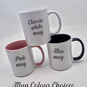 May include: Three white ceramic mugs with different colour accents and text. One mug has a pink interior and handle, another has a blue interior and handle, and the third is all white. Text on the mugs reads "Classic white mug", "Pink mug", and "Blue mug". The text "Mug Colour Choices" is also present.