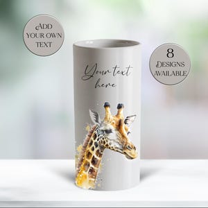 May include: A cylindrical, light gray ceramic vase featuring a watercolor illustration of a giraffe's head and neck. The giraffe has a brown and yellow patterned coat. The text "Your text here" is written on the vase. Two circles with text are also present.