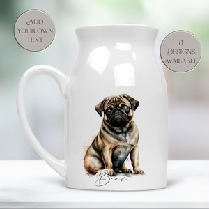 May include: White ceramic pitcher with a large handle, featuring a watercolor illustration of a pug dog. The dog is brown and black with a sweet expression. The name "Bean" is written below the dog. Text on the pitcher says "Add Your Own Text" and "8 Designs Available."