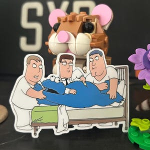 May include: A sticker featuring a cartoon scene of three men attending to a blue Cookie Monster character lying in a bed. A brown Lego-style hamster is in the background. The scene is set against a dark background.