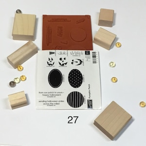 May include: A set of rubber stamps and wooden blocks for crafting, featuring a sheet with pumpkin face designs, oval patterns, and text that reads from our patch to yours happy halloween and sending halloween smiles across the miles.