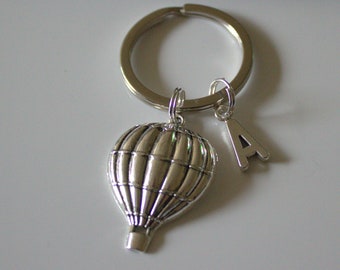 Keychain with the word serene stamped on a washer with hot air balloon charm and green crystal.