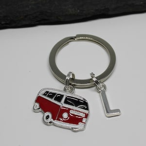 May include: Red and white Volkswagen bus keychain with a silver letter L charm.