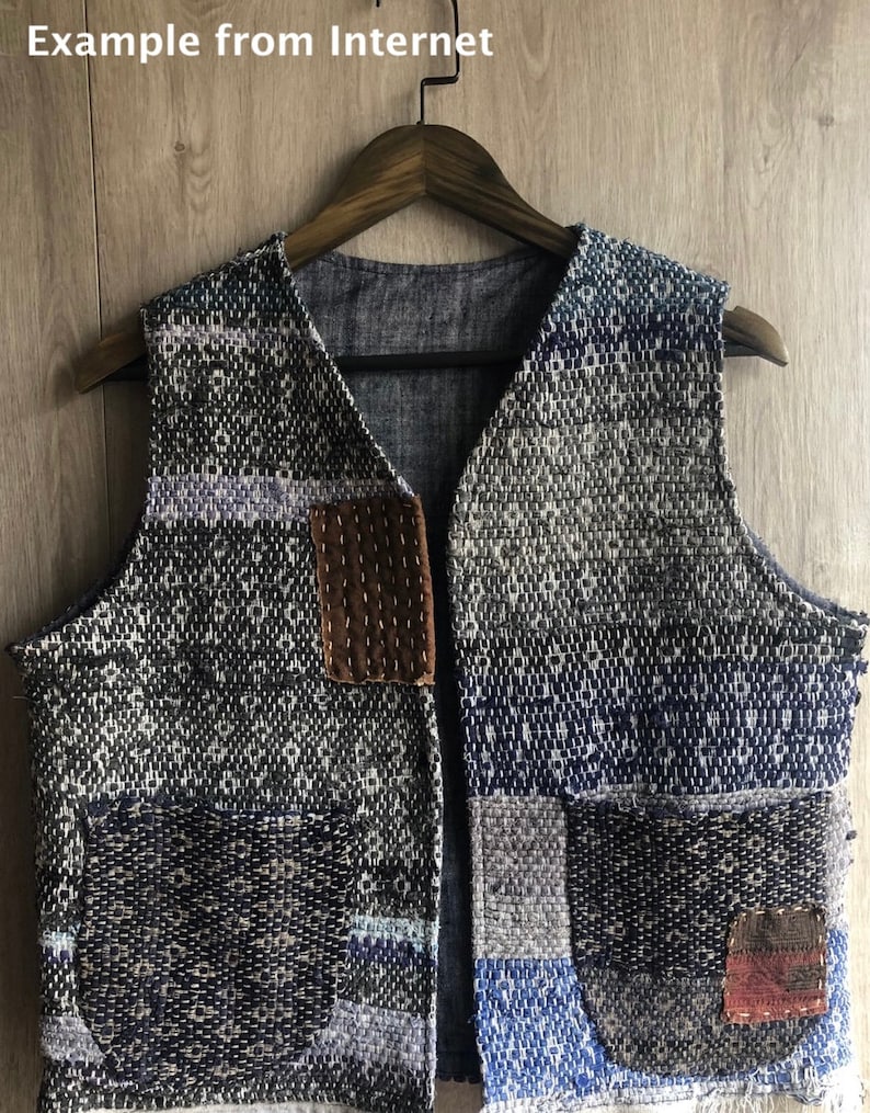 May include: A blue and grey patchwork vest with a brown leather patch and multiple pockets. The vest is made of a woven fabric and has a V-neck.