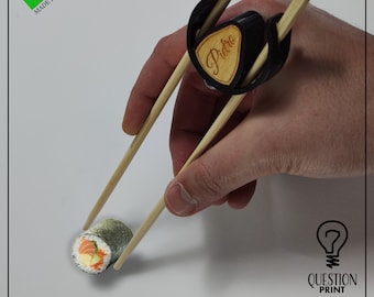 Sushi chopstick adapter clip. Helps in the use of chopsticks, pocket-sized and customizable keychain