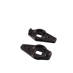 Może przedstawiać: Dwa czarne plastikowe elementy z kwadratowym otworem w środku. Elementy są zaprojektowane tak, aby pasowały do siebie.