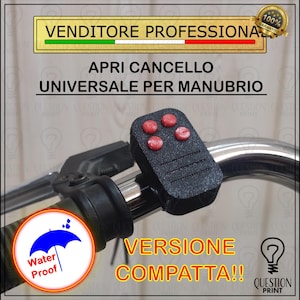 Könnte beinhalten: Eine schwarze Fernbedienung mit vier roten Knöpfen ist an einem Fahrradlenker befestigt. Der Text "APRI CANCELLO UNIVERSALE PER MANUBRIO" ist sichtbar. Das Bild enthält auch den Text "Water Proof" und "VERSIONE COMPATTA!!".