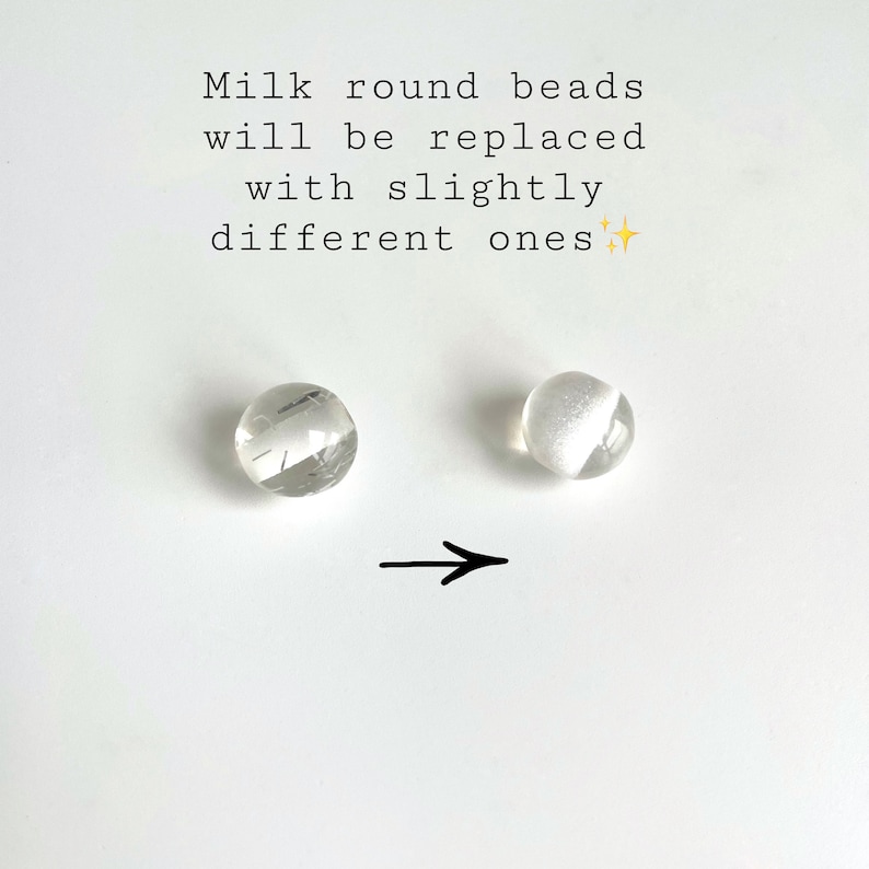 May include: Two clear, round beads on a white background. The bead on the left has internal lines, while the bead on the right has a white, glittery section. Text above reads: "Milk round beads will be replaced with slightly different ones."
