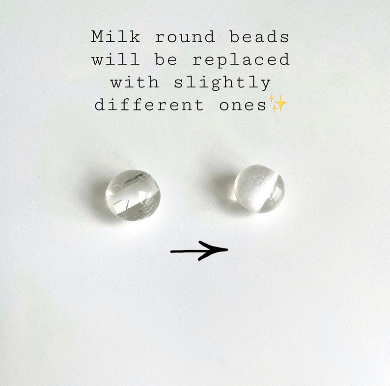 Peut inclure: Deux perles rondes transparentes, l'une avec une finition plus opaque que l'autre. Une fl&egrave;che pointe de la perle la plus opaque vers la perle la moins opaque. Le texte "Milk round beads will be replaced with slightly different ones" est au-dessus des perles.