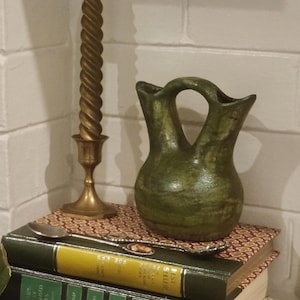 May include: A white ceramic mug with a black handle and the text "But First, Coffee" in a black, bold font. The mug is on a white surface. The mug is 4 inches tall.