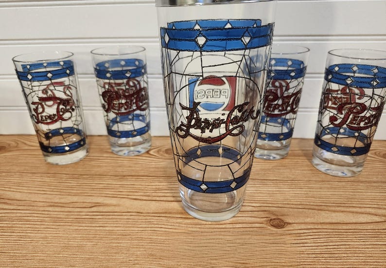 May include: Set of five vintage Pepsi-Cola glasses. Each glass features a stained-glass design with blue, white, and red accents. The Pepsi logo is prominently displayed on each glass, making them a collectible item.