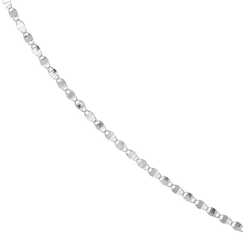 May include: A delicate silver chain necklace with a repeating pattern of flat, oval-shaped links. The links have a textured, reflective surface, creating a subtle sparkle. The chain is displayed against a plain white background.