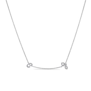 以下が含まれることがあります： 小さなダイヤモンドで飾られた「C」と「G」の2つの文字がぶら下がっている、繊細なシルバーチェーンネックレスです。