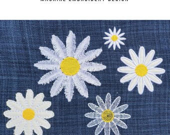 May include: Machine embroidery design showing white daisy flowers with yellow centres on a blue background. The text at the top reads "DAISY FLOWER MACHINE EMBROIDERY DESIGN". The text at the bottom reads "MULTIPLE SIZES IN DIFFERENT FORMATS".
