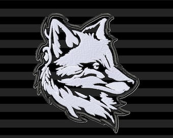 May include: A white and black embroidered fox head patch. The fox is facing right, with detailed fur and facial features. The background is black with horizontal grey stripes. The image includes the text "KRAFTYGRAPHY EMBROIDERY CUTTING PRINTING" and "DIGITAL FILES".